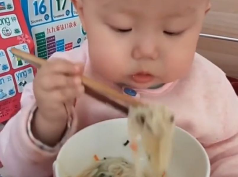 Wow, baby eet noodles met stokjes als een pro!